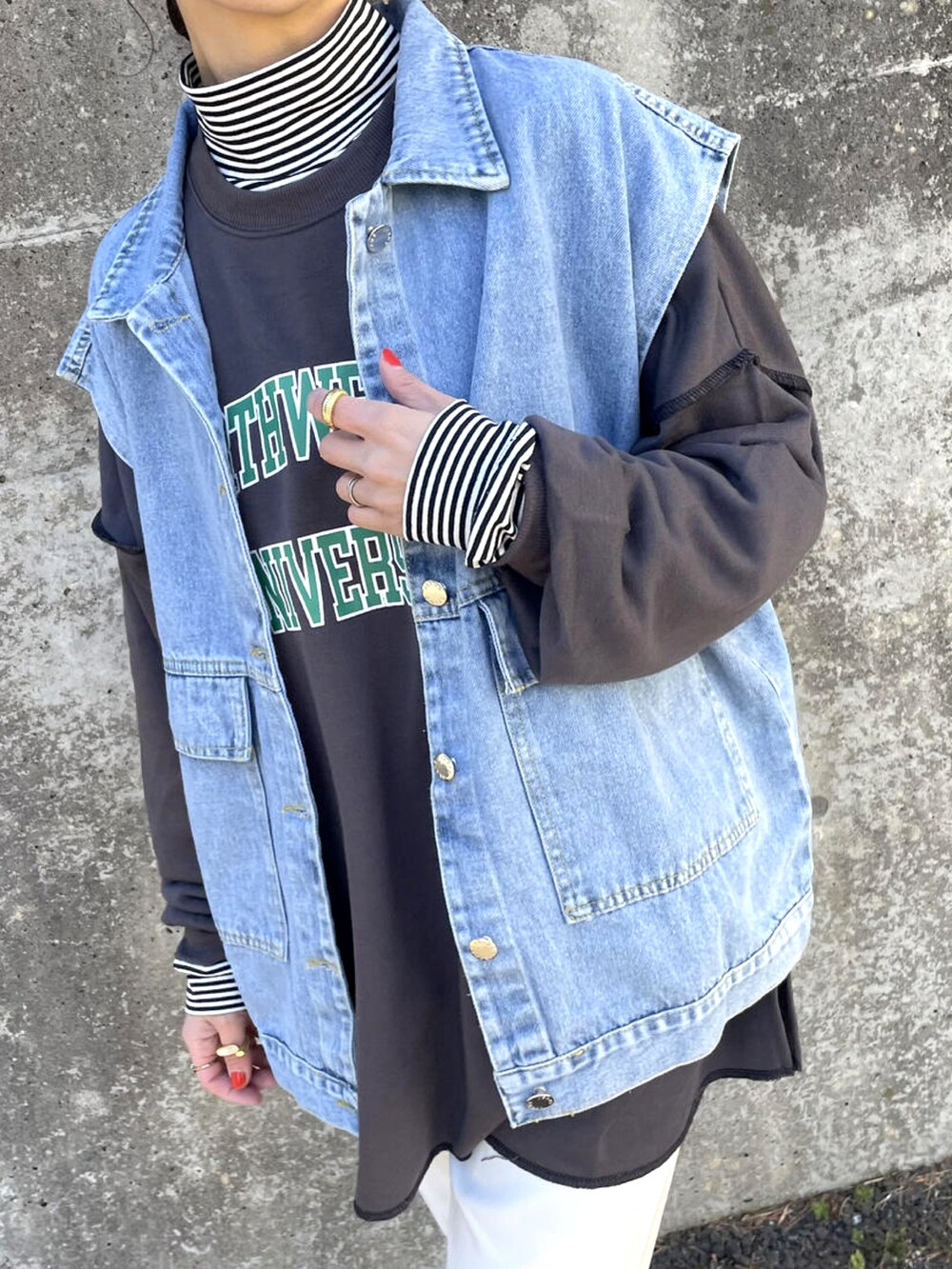 ブルー系のデニムジャケット、ブラック系のスウェット、その他のトップスを着用したレディースの春コーディネートの3枚目の写真