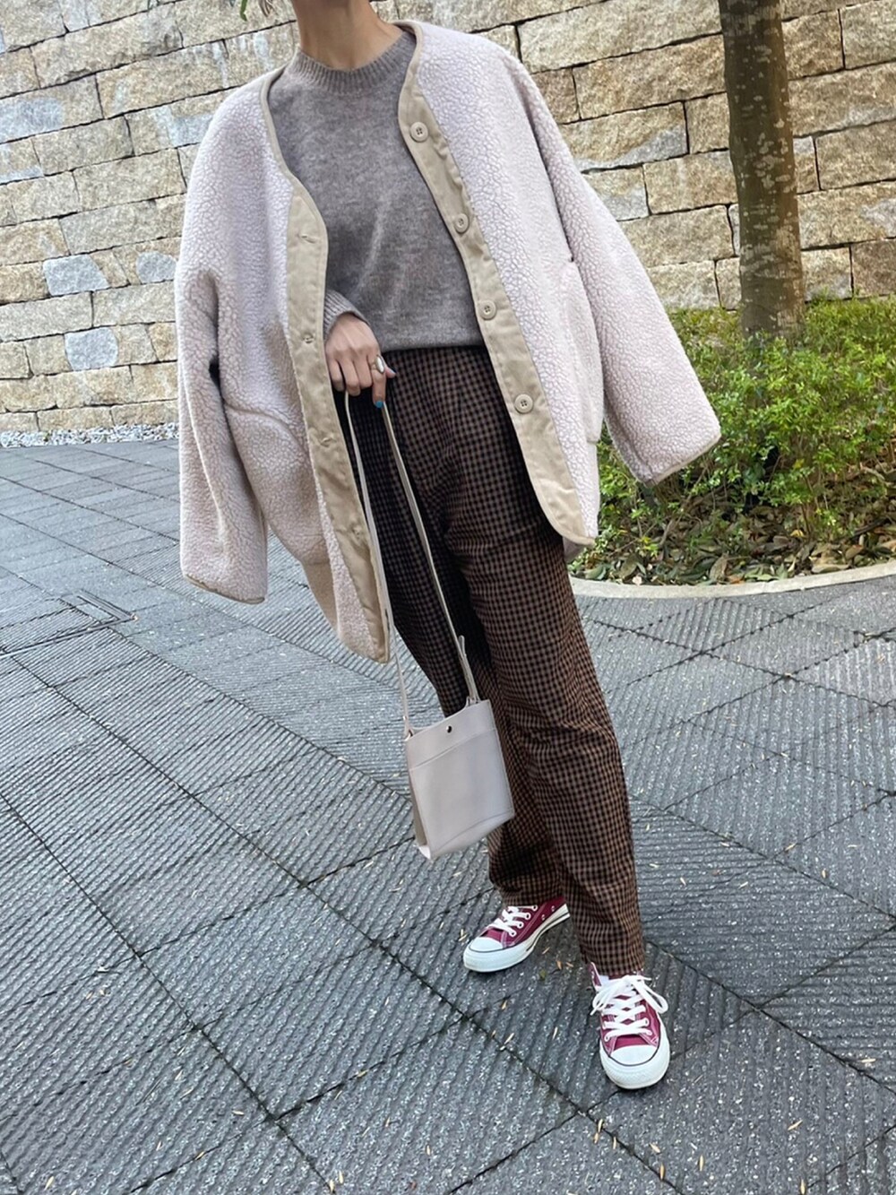 ホワイト系のニット/セーター、ブラウン系のその他パンツ、レッド系のスニーカーを着用したレディースの冬コーディネートの2枚目の写真