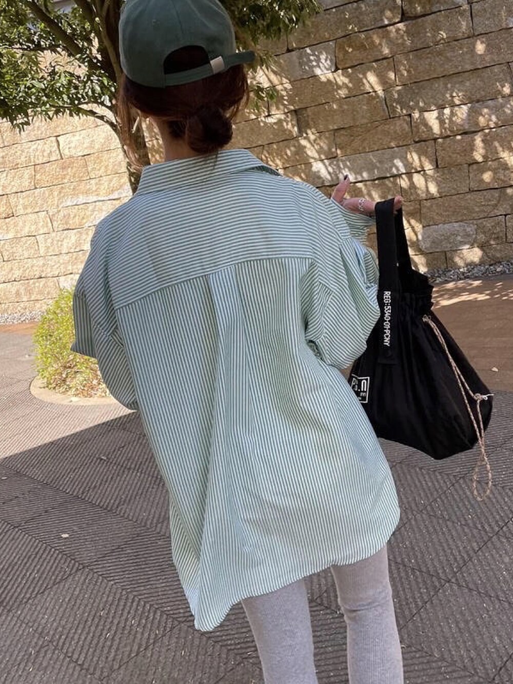 グリーン系のシャツ/ブラウス、ブラック系のスニーカー、ホワイト系のTシャツ/カットソーを着用したレディースの冬コーディネートの5枚目の写真
