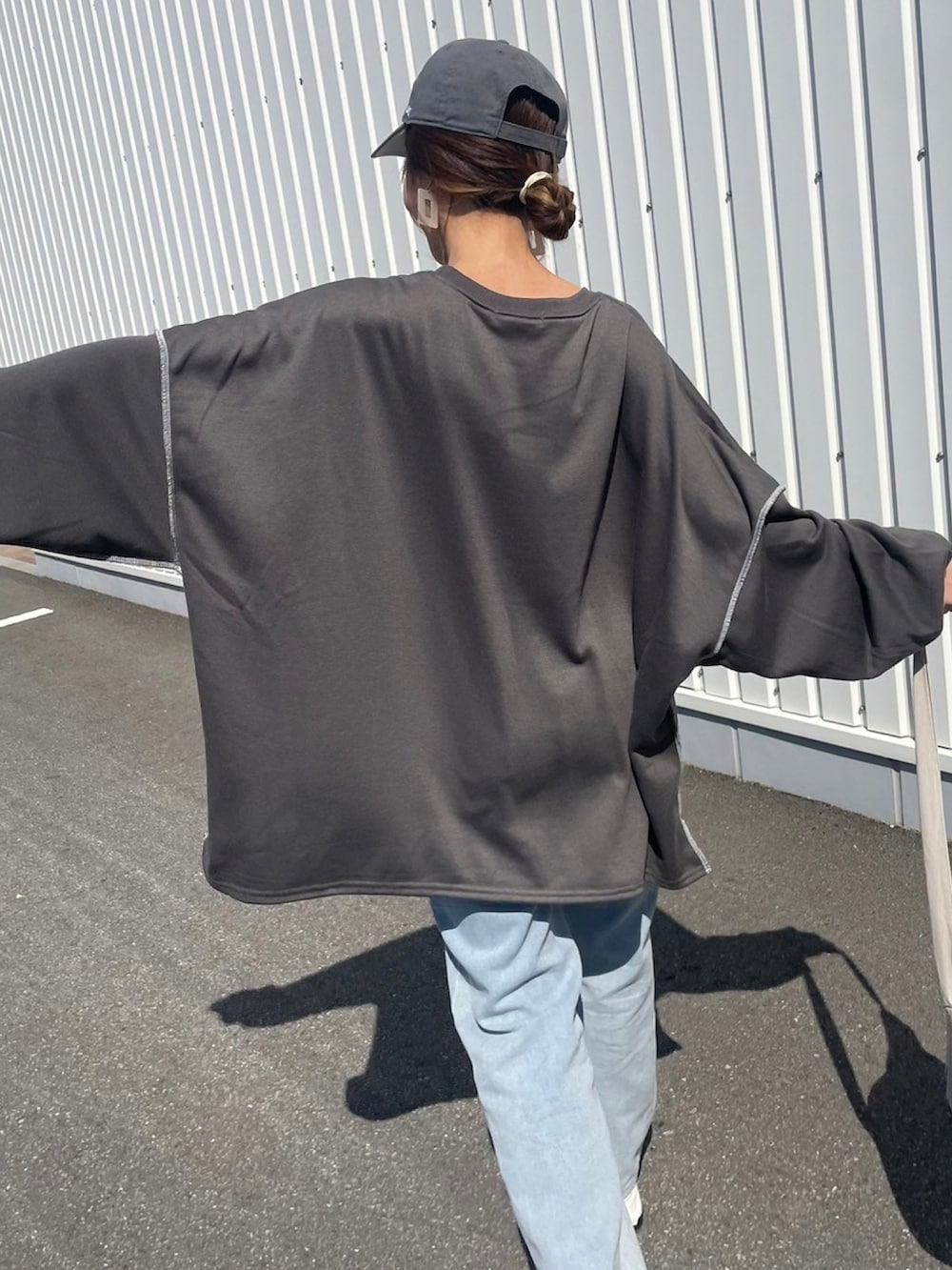 グレー系のスウェット、ブルー系のデニムパンツ、ホワイト系のバックパック/リュックを着用したレディースの春コーディネートの5枚目の写真