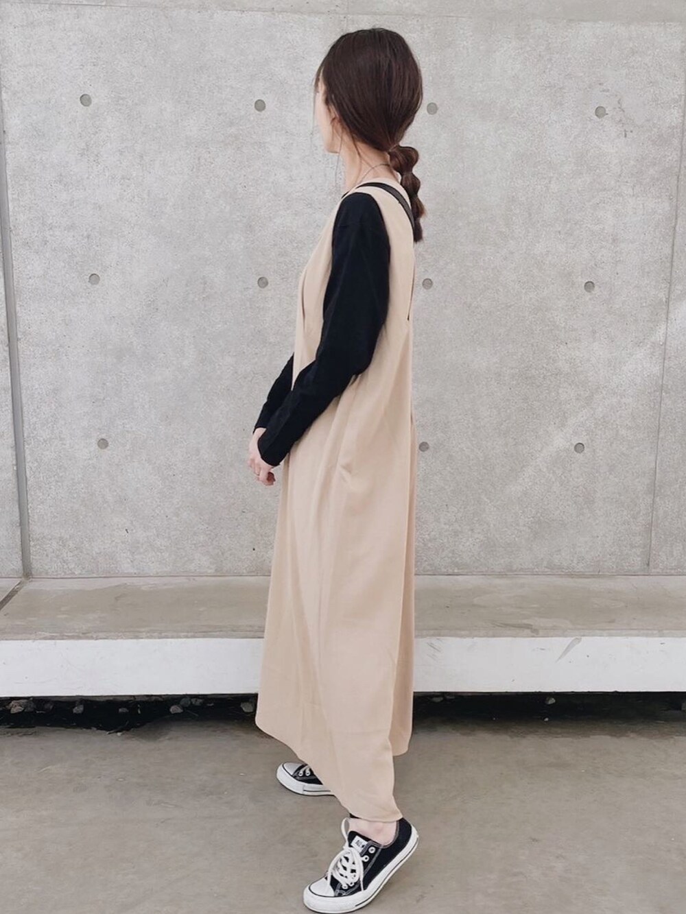 ベージュ系のワンピース、ブラック系のTシャツ/カットソー、ブラック系のスニーカーを着用したレディースの春コーディネートの5枚目の写真