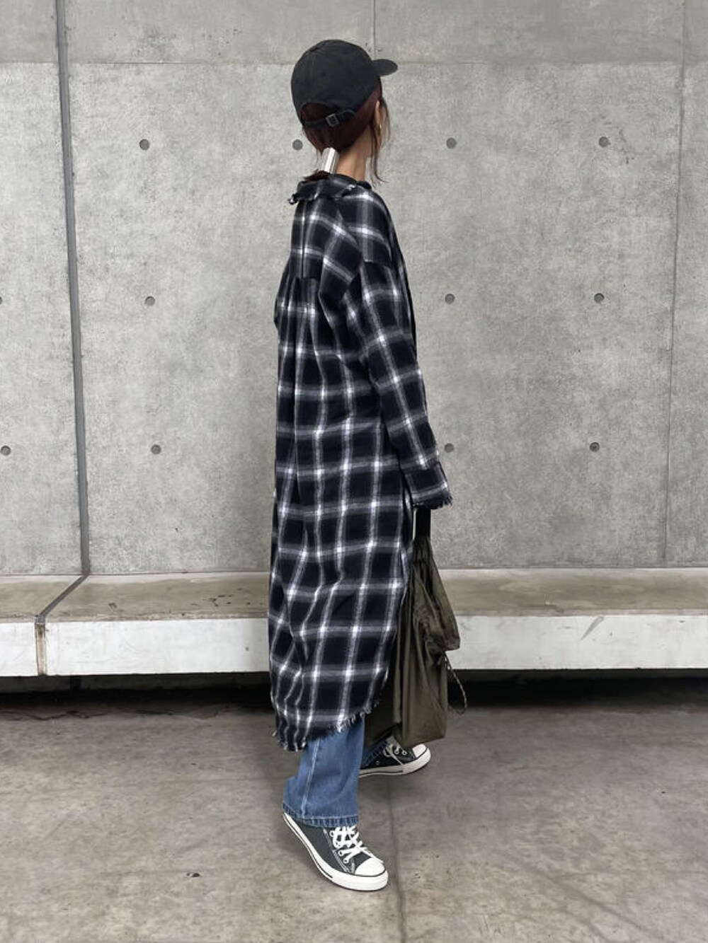 ホワイト系のTシャツ/カットソー、ブラック系のシャツワンピース、ブルー系のデニムパンツを着用したレディースの秋コーディネートの3枚目の写真