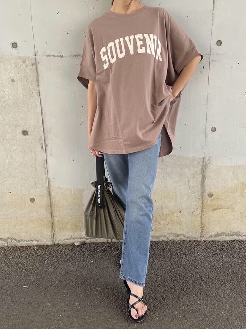 ブラウン系のTシャツ/カットソー、ブルー系のデニムパンツ、グリーン系のエコバッグ/サブバッグを着用したレディースの夏コーディネートの3枚目の写真