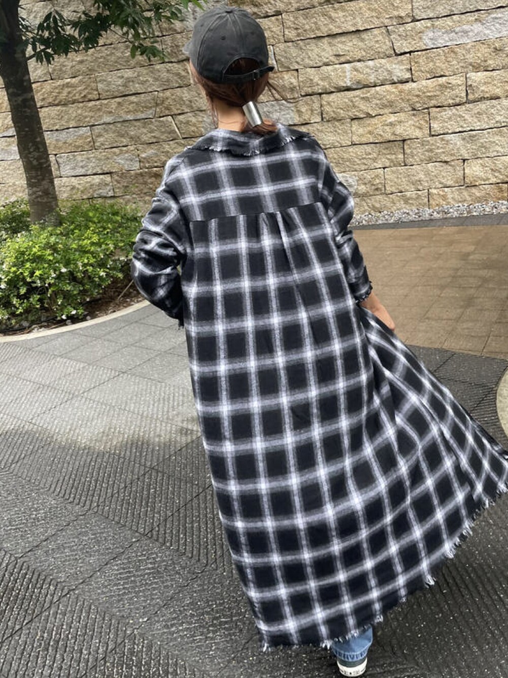 ホワイト系のTシャツ/カットソー、ブラック系のシャツワンピース、ブルー系のデニムパンツを着用したレディースの秋コーディネートの5枚目の写真