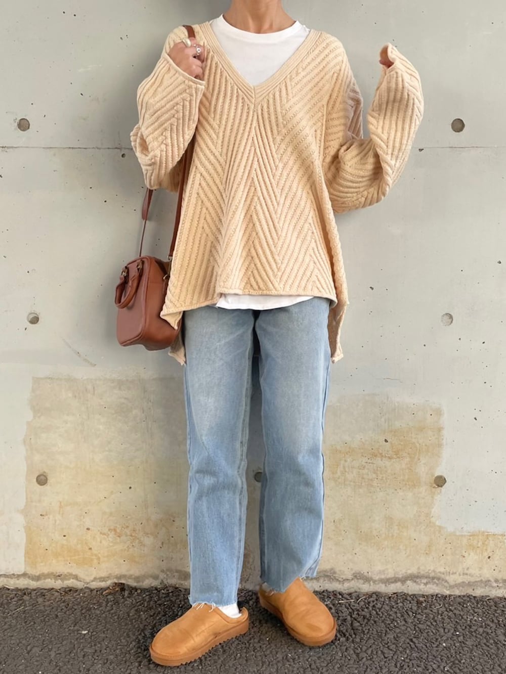 ホワイト系のニット/セーター、ブルー系のデニムパンツ、イエロー系のスリッポンを着用したレディースの冬コーディネートの2枚目の写真