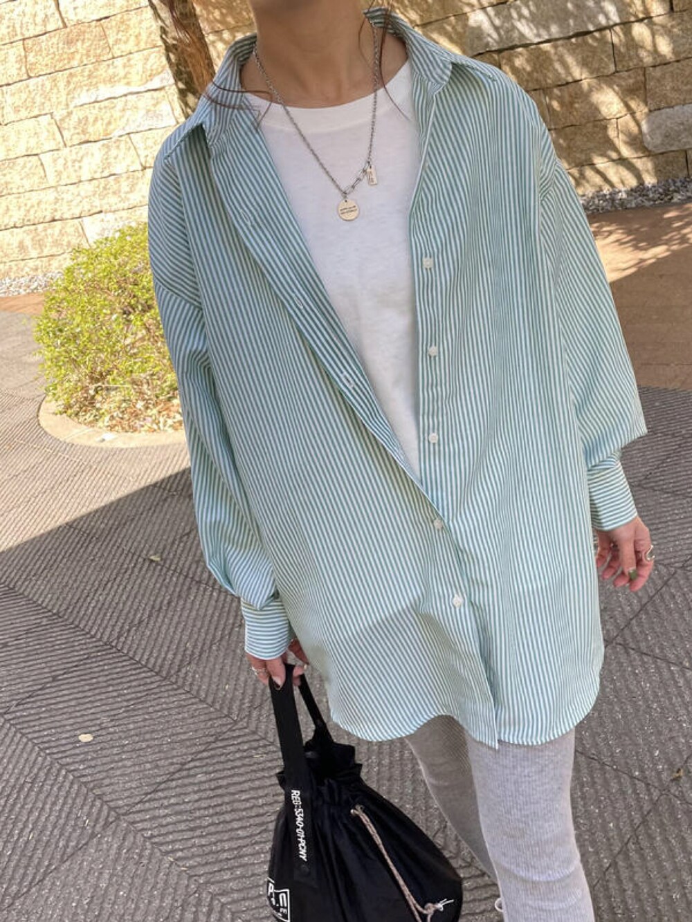 グリーン系のシャツ/ブラウス、ブラック系のスニーカー、ホワイト系のTシャツ/カットソーを着用したレディースの冬コーディネートの4枚目の写真