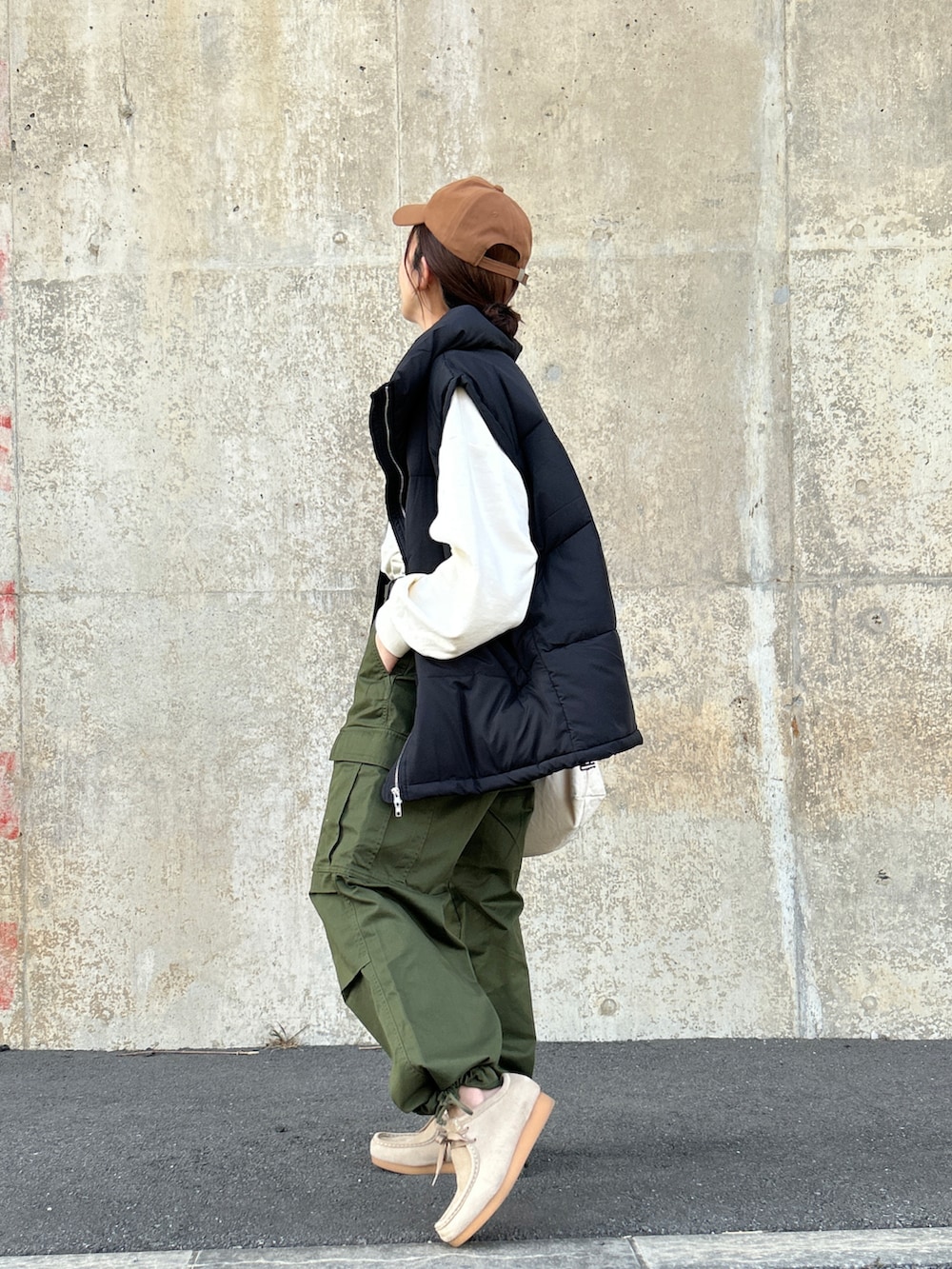 ホワイト系のスウェット、ブラック系のダウンベスト、グリーン系のカーゴパンツを着用したレディースの冬コーディネートの2枚目の写真