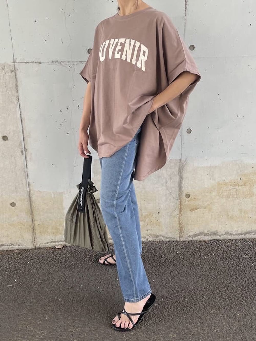 ブラウン系のTシャツ/カットソー、ブルー系のデニムパンツ、グリーン系のエコバッグ/サブバッグを着用したレディースの夏コーディネートの2枚目の写真