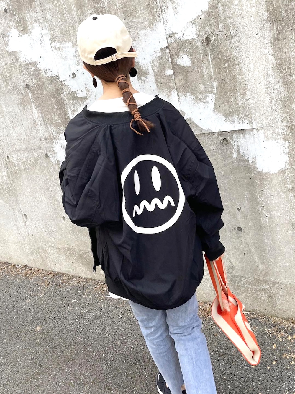 ブラック系のMA-1、ホワイト系のTシャツ/カットソー、オレンジ系のハンドバッグを着用したレディースの春コーディネートの4枚目の写真