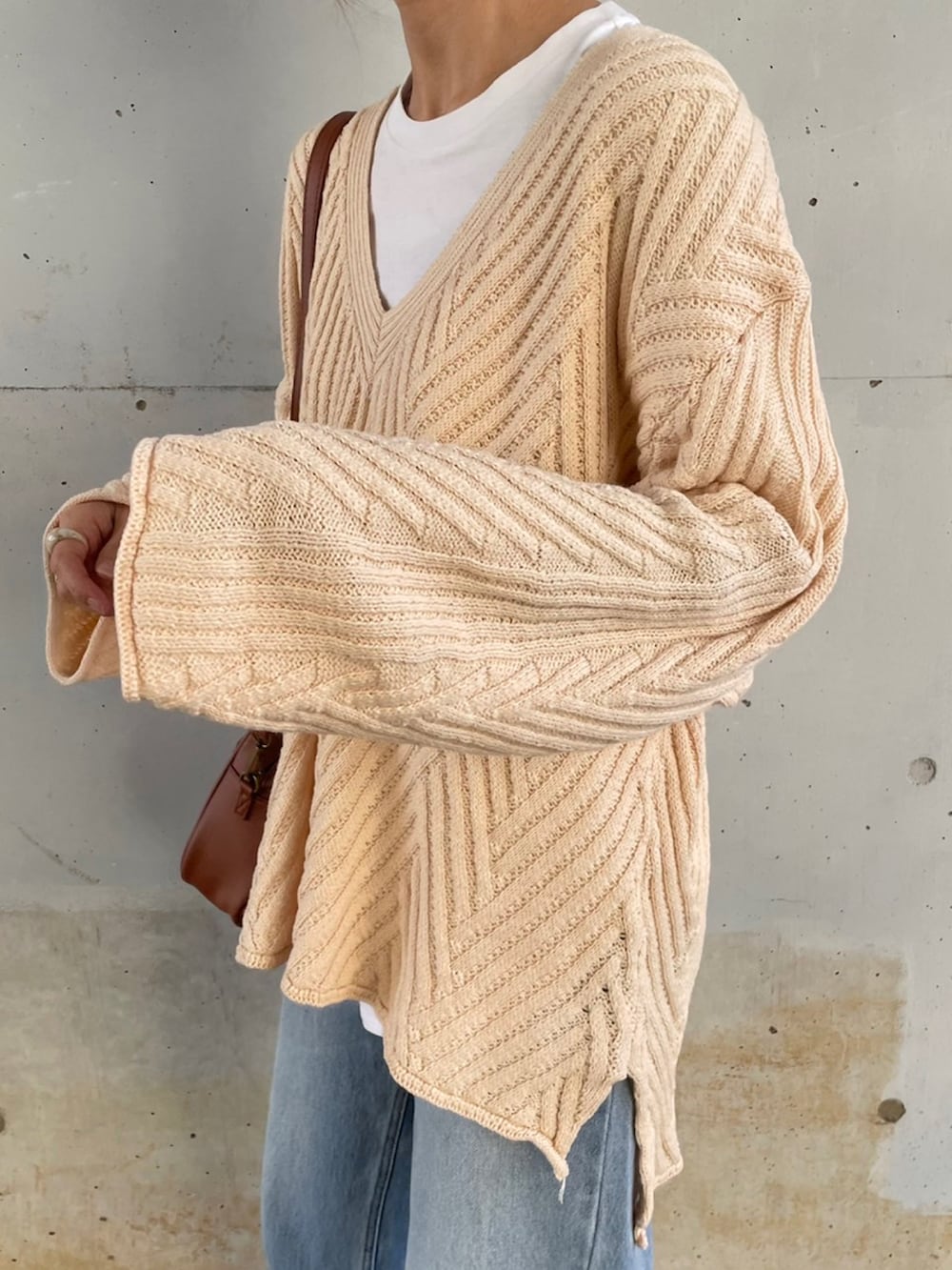 ホワイト系のニット/セーター、ブルー系のデニムパンツ、イエロー系のスリッポンを着用したレディースの冬コーディネートの3枚目の写真