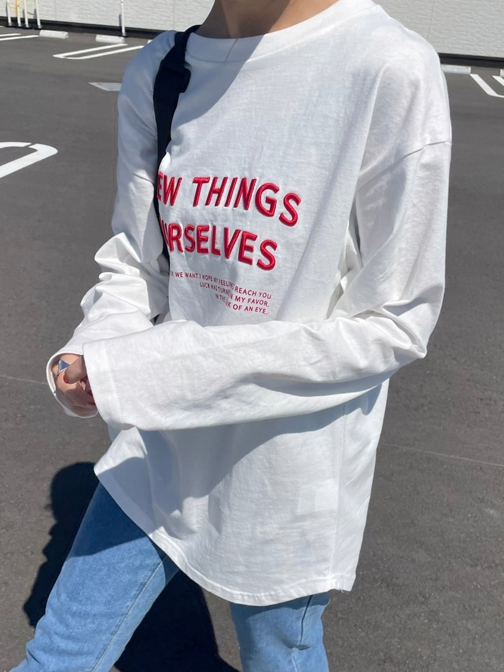 ホワイト系のTシャツ/カットソー、ブラック系のメッセンジャーバッグ、レッド系のスニーカーを着用したレディースの春コーディネートの2枚目の写真