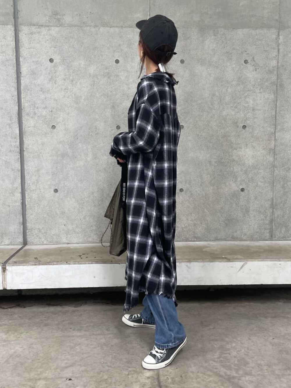 ホワイト系のTシャツ/カットソー、ブラック系のシャツワンピース、ブルー系のデニムパンツを着用したレディースの秋コーディネートの2枚目の写真