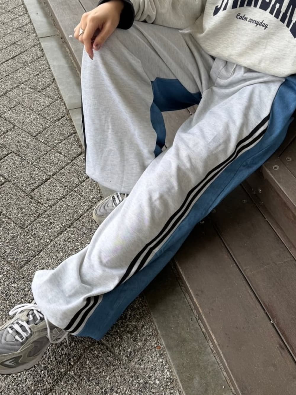 ブルー系のパンツ、グレー系のスニーカー、その他のスウェットを着用したレディースの冬コーディネートの5枚目の写真