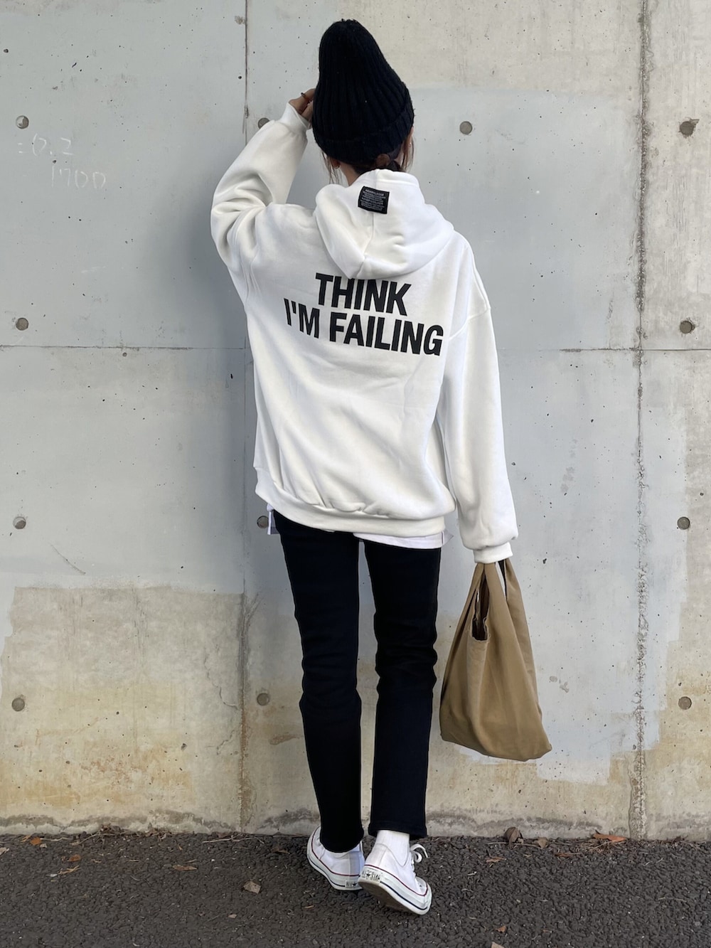 ホワイト系のパーカー、ブラック系のデニムパンツ、その他のエコバッグ/サブバッグを着用したレディースの冬コーディネートの4枚目の写真