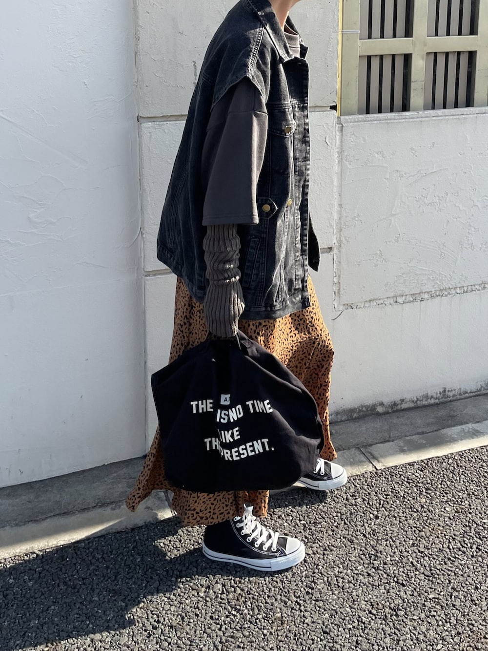 ブラック系のトップス、ブラック系のデニムジャケット、ブラウン系のスカートを着用したレディースの冬コーディネートの2枚目の写真