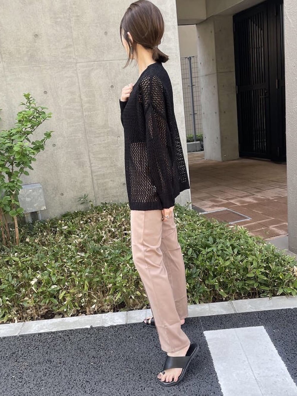 ブラック系のニット/セーター、ブラック系のタンクトップ、ベージュ系のショルダーバッグを着用したレディースの春コーディネートの3枚目の写真