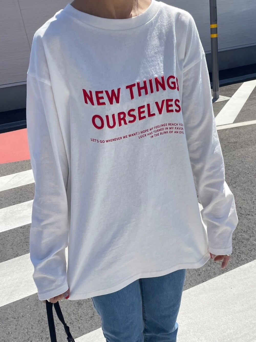 ホワイト系のTシャツ/カットソー、ブラック系のメッセンジャーバッグ、レッド系のスニーカーを着用したレディースの春コーディネートの3枚目の写真