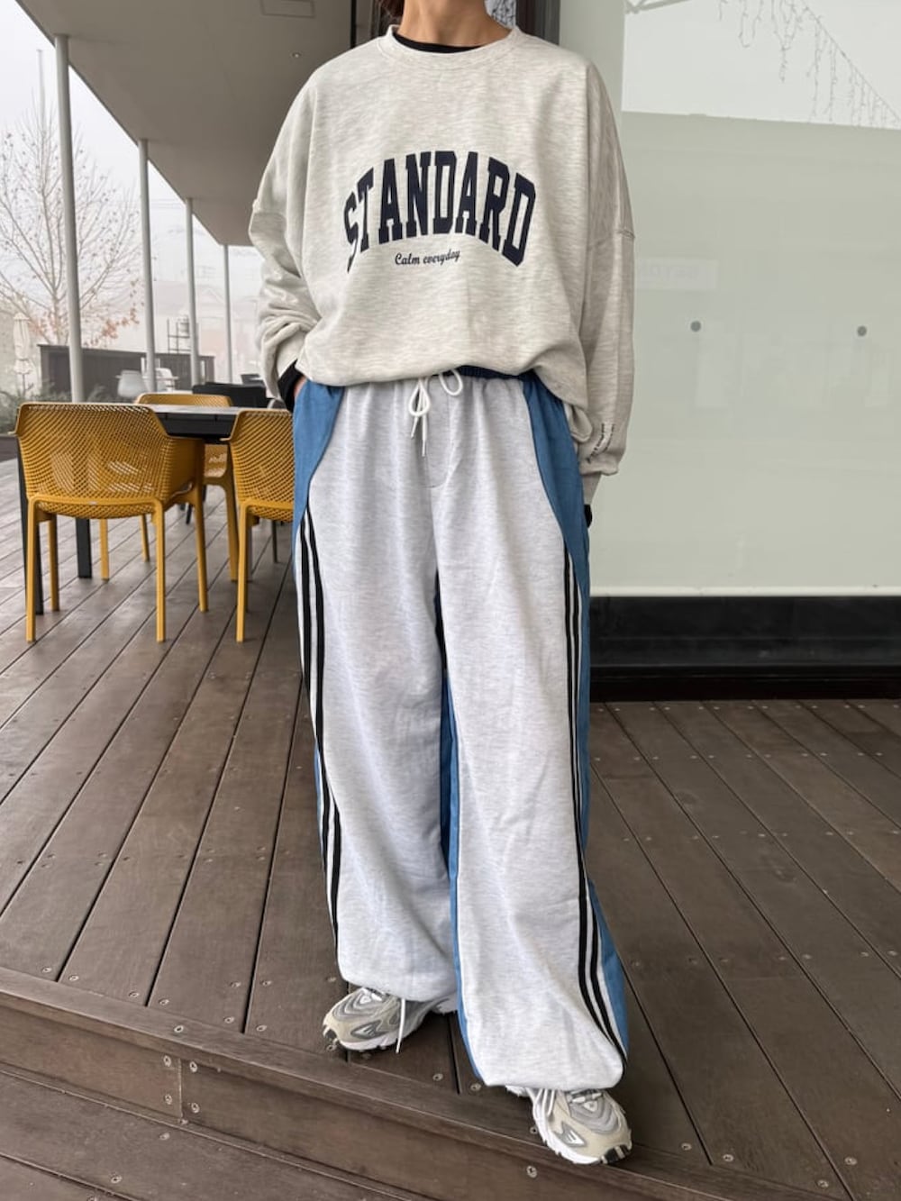 ブルー系のパンツ、グレー系のスニーカー、その他のスウェットを着用したレディースの冬コーディネートの3枚目の写真