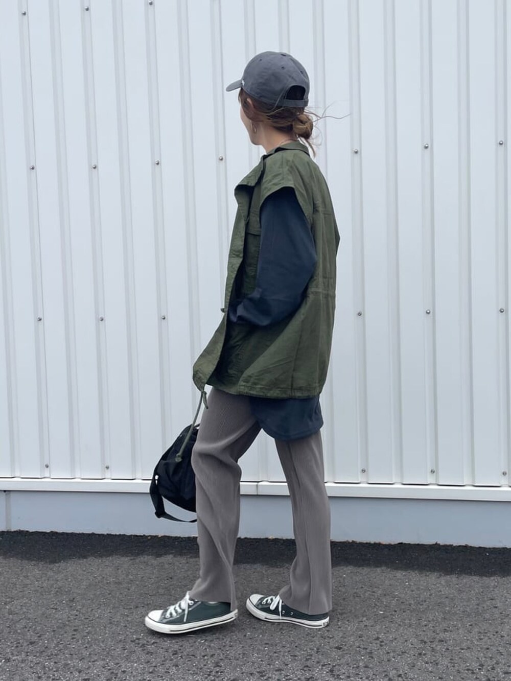 グリーン系のミリタリージャケット、ブラック系のTシャツ/カットソー、ブラック系のメッセンジャーバッグを着用したレディースの春コーディネートの2枚目の写真