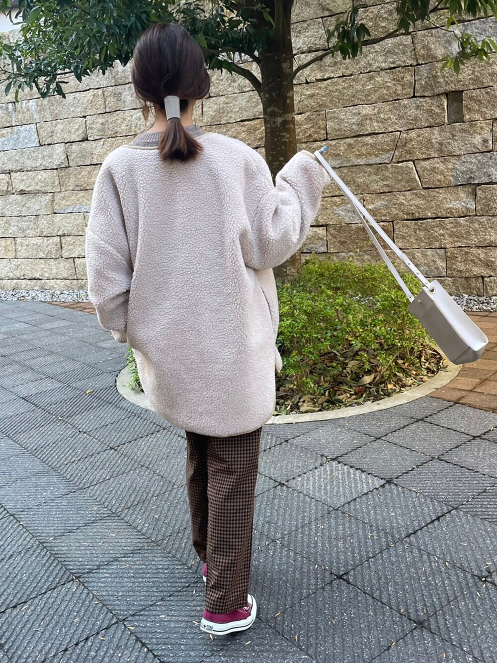 ホワイト系のニット/セーター、ブラウン系のその他パンツ、レッド系のスニーカーを着用したレディースの冬コーディネートの4枚目の写真