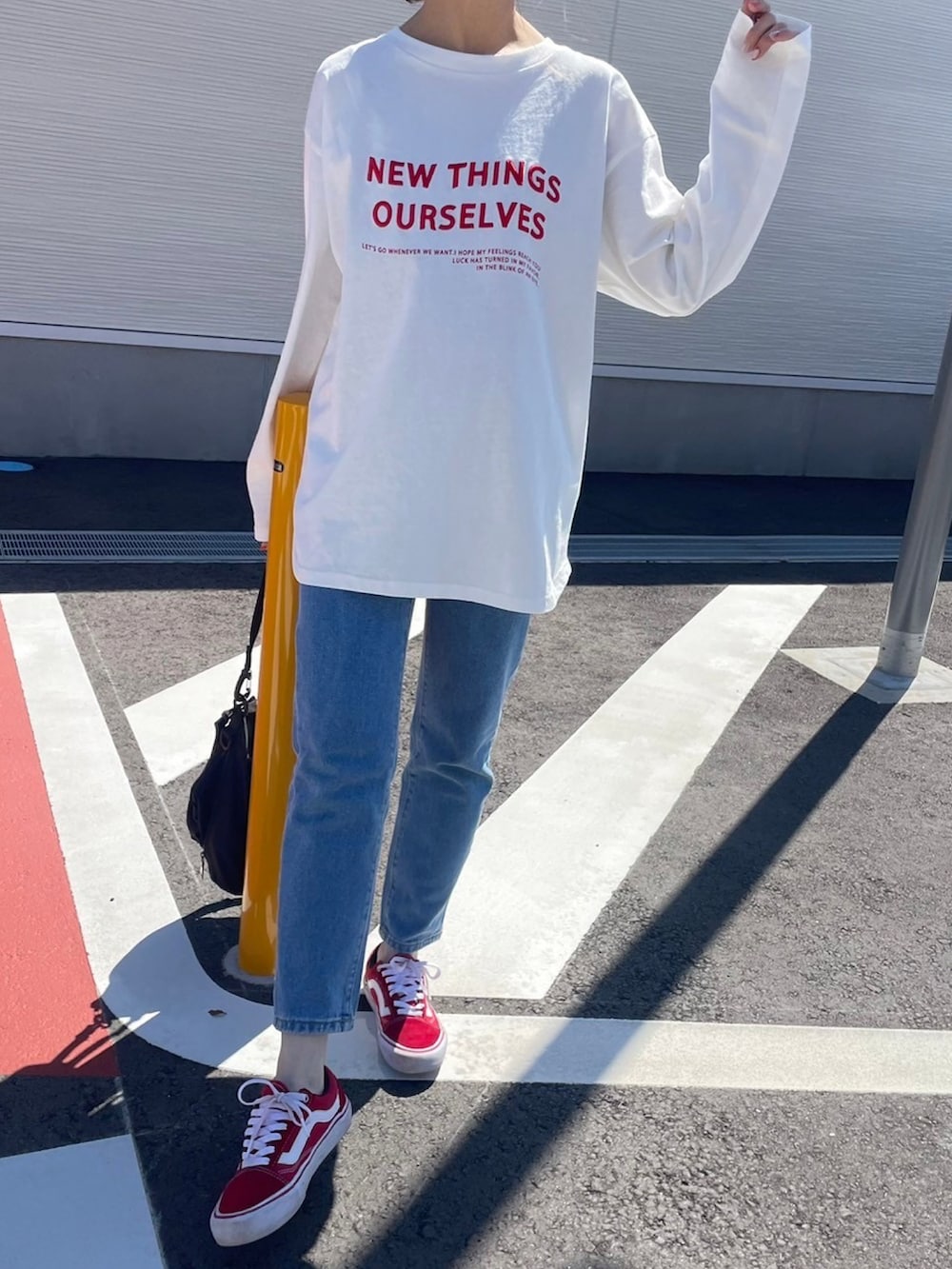 ホワイト系のTシャツ/カットソー、ブラック系のメッセンジャーバッグ、レッド系のスニーカーを着用したレディースの春コーディネートの4枚目の写真