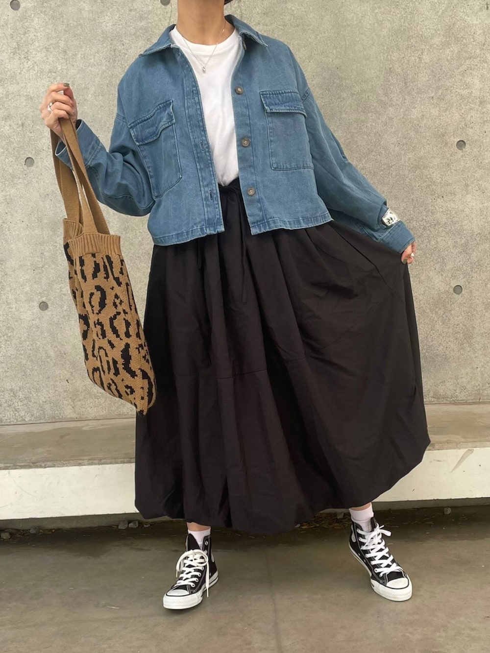 ブルー系のデニムジャケット、ブラック系のスカート、ホワイト系のTシャツ/カットソーを着用したレディースの冬コーディネートの2枚目の写真