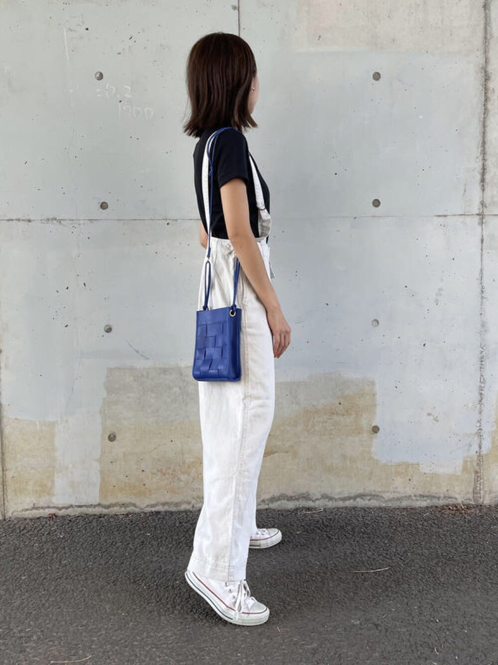 ブラック系のTシャツ/カットソー、ホワイト系のサロペット/オーバーオール、ホワイト系のショルダーバッグを着用したレディースの夏コーディネートの2枚目の写真