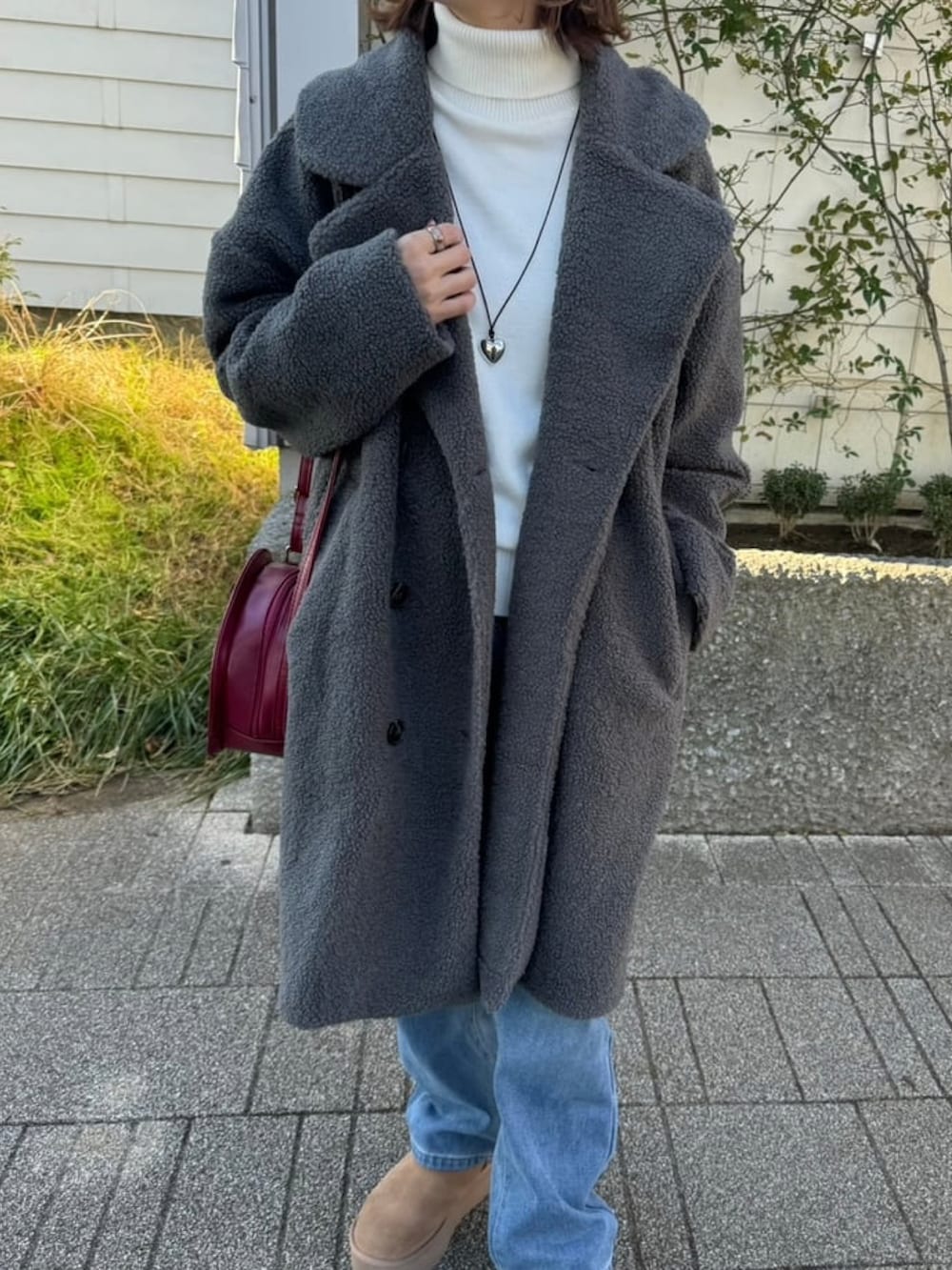 グレー系のその他アウター、ホワイト系のニット/セーター、ブルー系のデニムパンツを着用したレディースの冬コーディネートの5枚目の写真