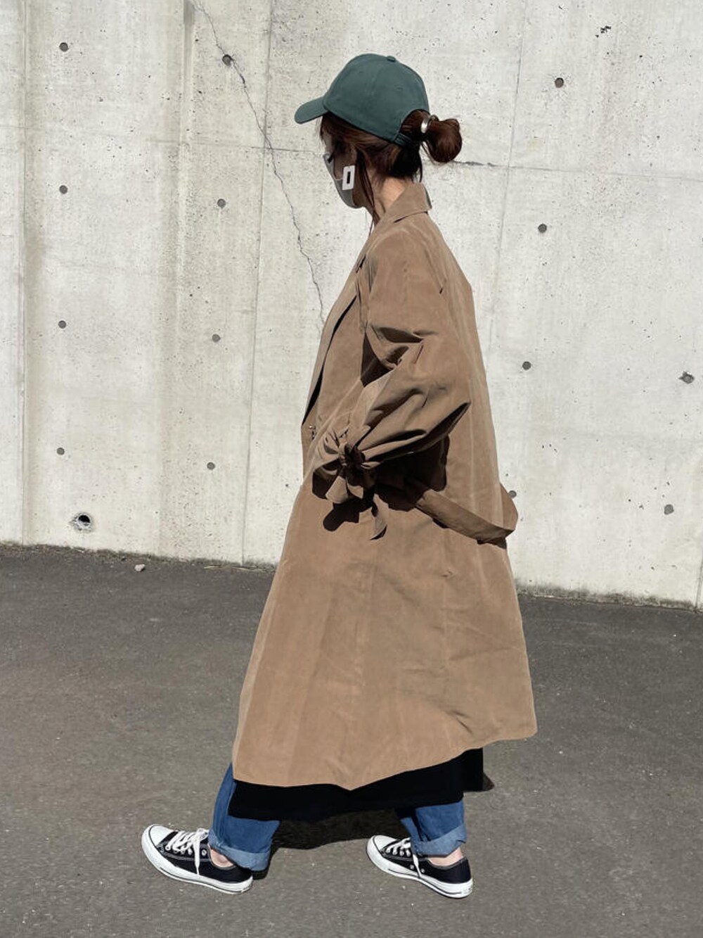 ブラック系のワンピース、ブラウン系のトレンチコート、ブラック系のショルダーバッグを着用したレディースの春コーディネートの4枚目の写真