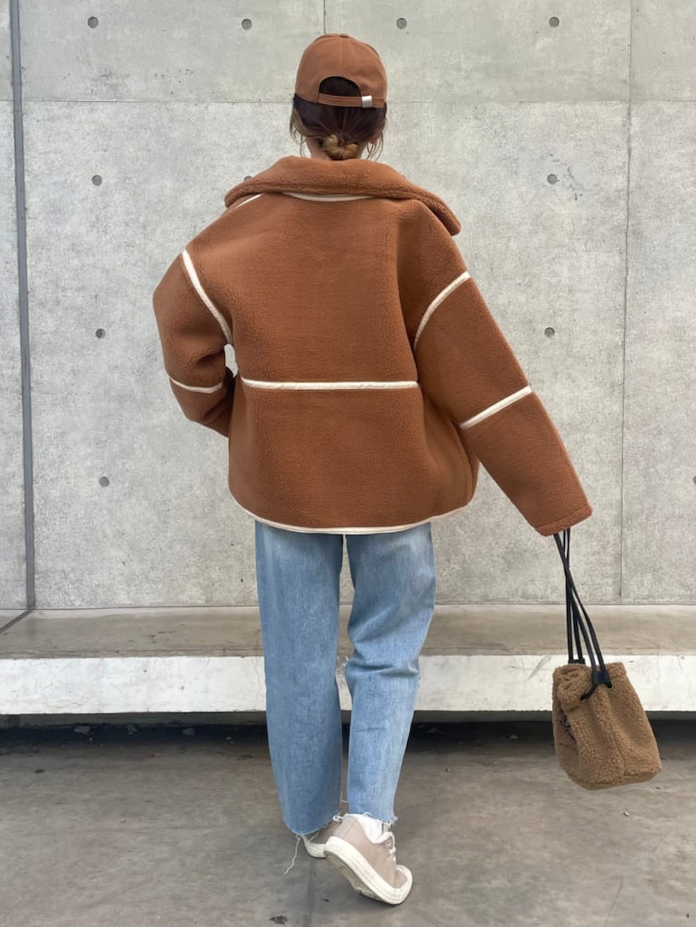 ブラウン系のその他アウター、ブルー系のデニムパンツ、その他のハンドバッグを着用したレディースの冬コーディネートの2枚目の写真