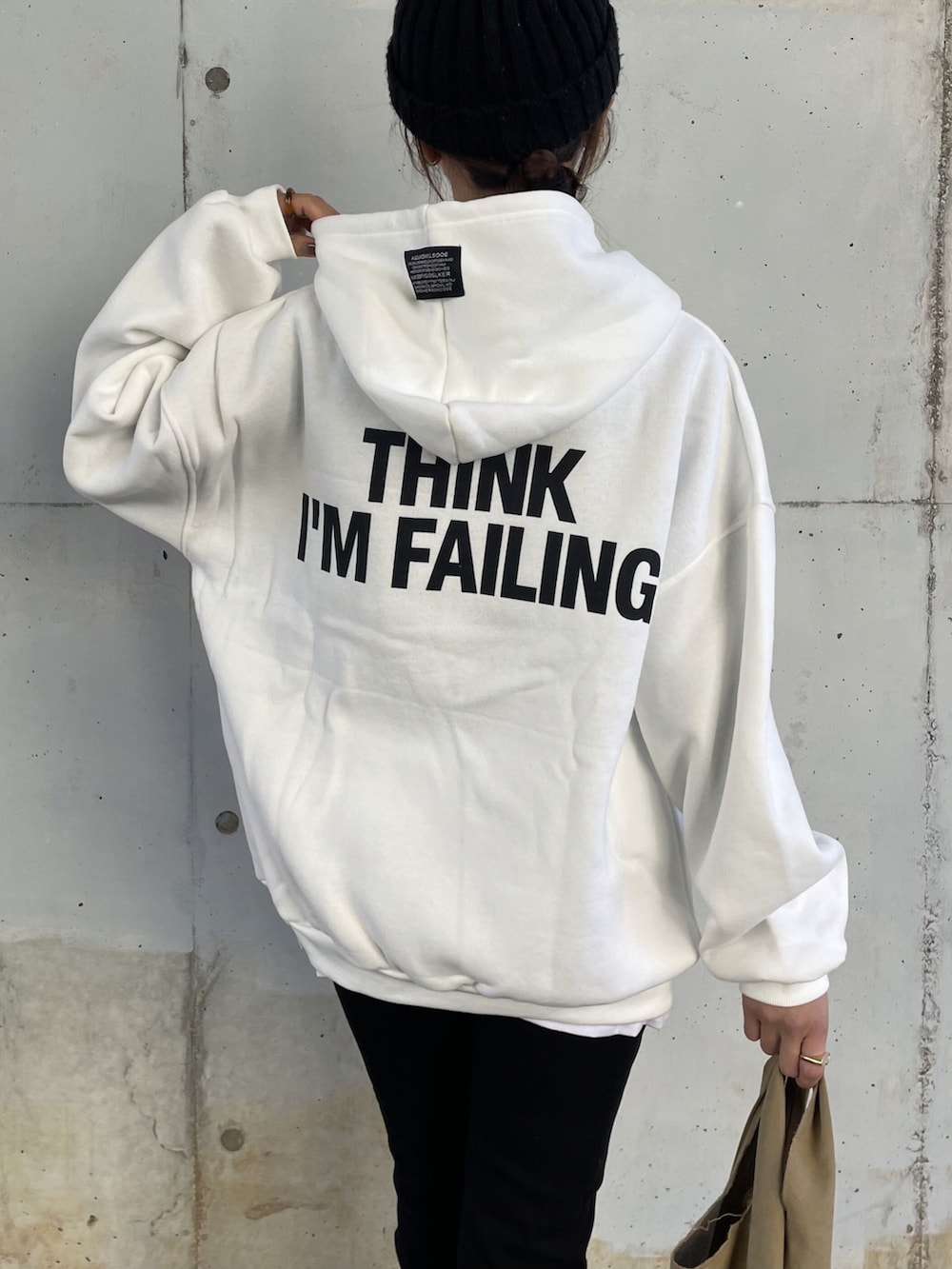 ホワイト系のパーカー、ブラック系のデニムパンツ、その他のエコバッグ/サブバッグを着用したレディースの冬コーディネートの5枚目の写真