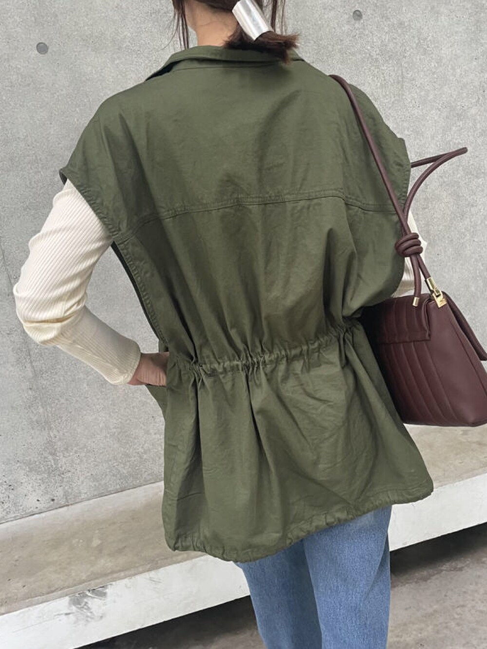 ホワイト系のTシャツ/カットソー、グリーン系のベスト、ブラウン系のショルダーバッグを着用したレディースの秋コーディネートの5枚目の写真