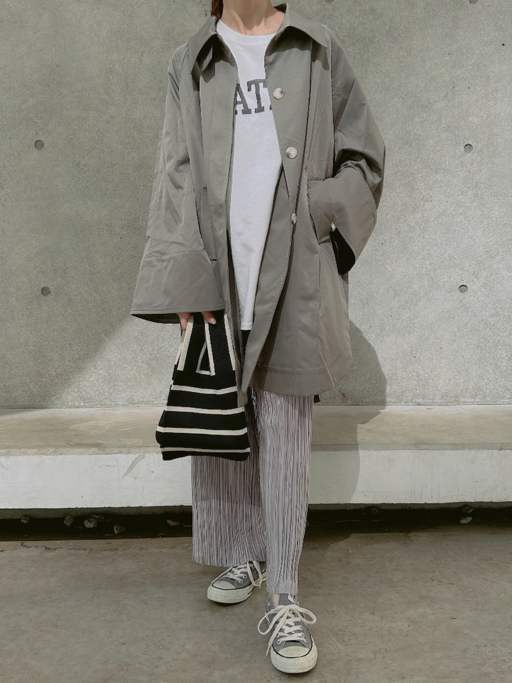 グリーン系のステンカラーコート、パープル系のその他パンツ、グレー系のスニーカーを着用したレディースの春コーディネートの2枚目の写真