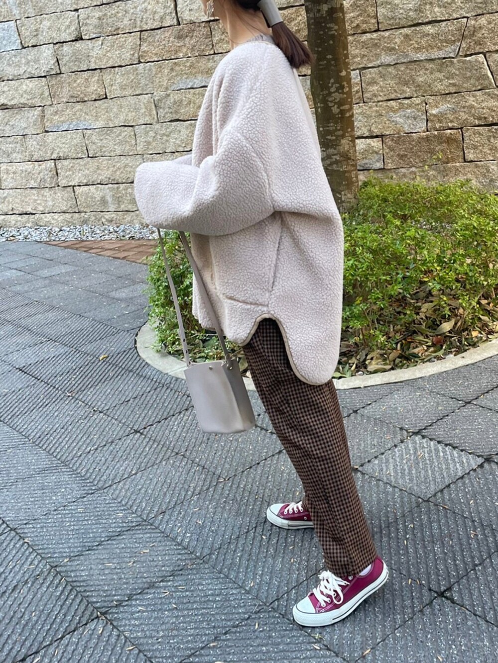 ホワイト系のニット/セーター、ブラウン系のその他パンツ、レッド系のスニーカーを着用したレディースの冬コーディネートの3枚目の写真