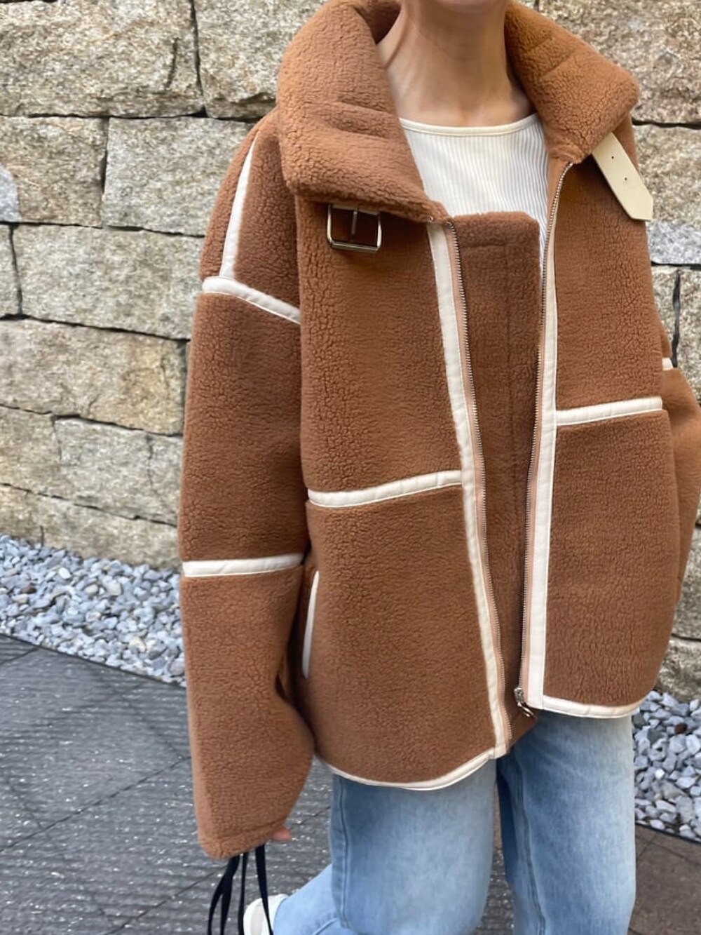 ブラウン系のその他アウター、ブルー系のデニムパンツ、その他のハンドバッグを着用したレディースの冬コーディネートの4枚目の写真