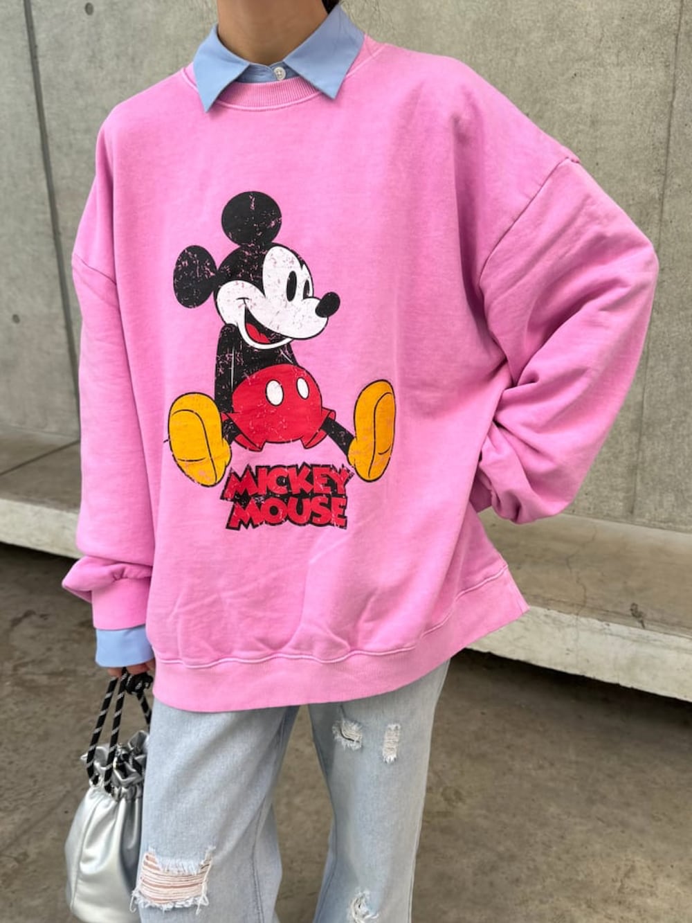 ピンク系のスウェット、シルバー系のバッグ、ブルー系のシャツ/ブラウスを着用したレディースの冬コーディネートの4枚目の写真