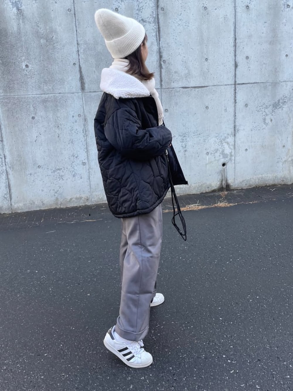 グレー系のスウェット、グレー系のパンツ、ホワイト系のスニーカーを着用したレディースの冬コーディネートの3枚目の写真