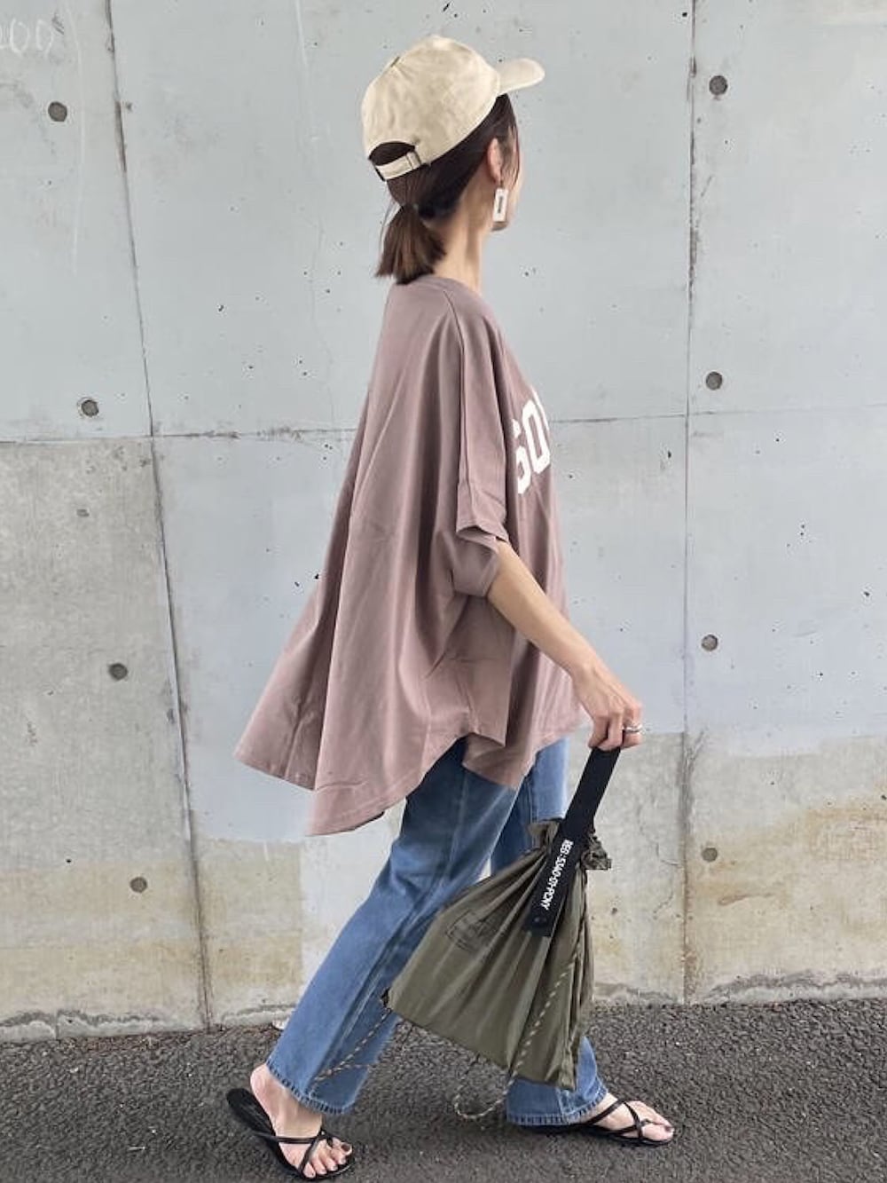 ブラウン系のTシャツ/カットソー、ブルー系のデニムパンツ、グリーン系のエコバッグ/サブバッグを着用したレディースの夏コーディネートの5枚目の写真