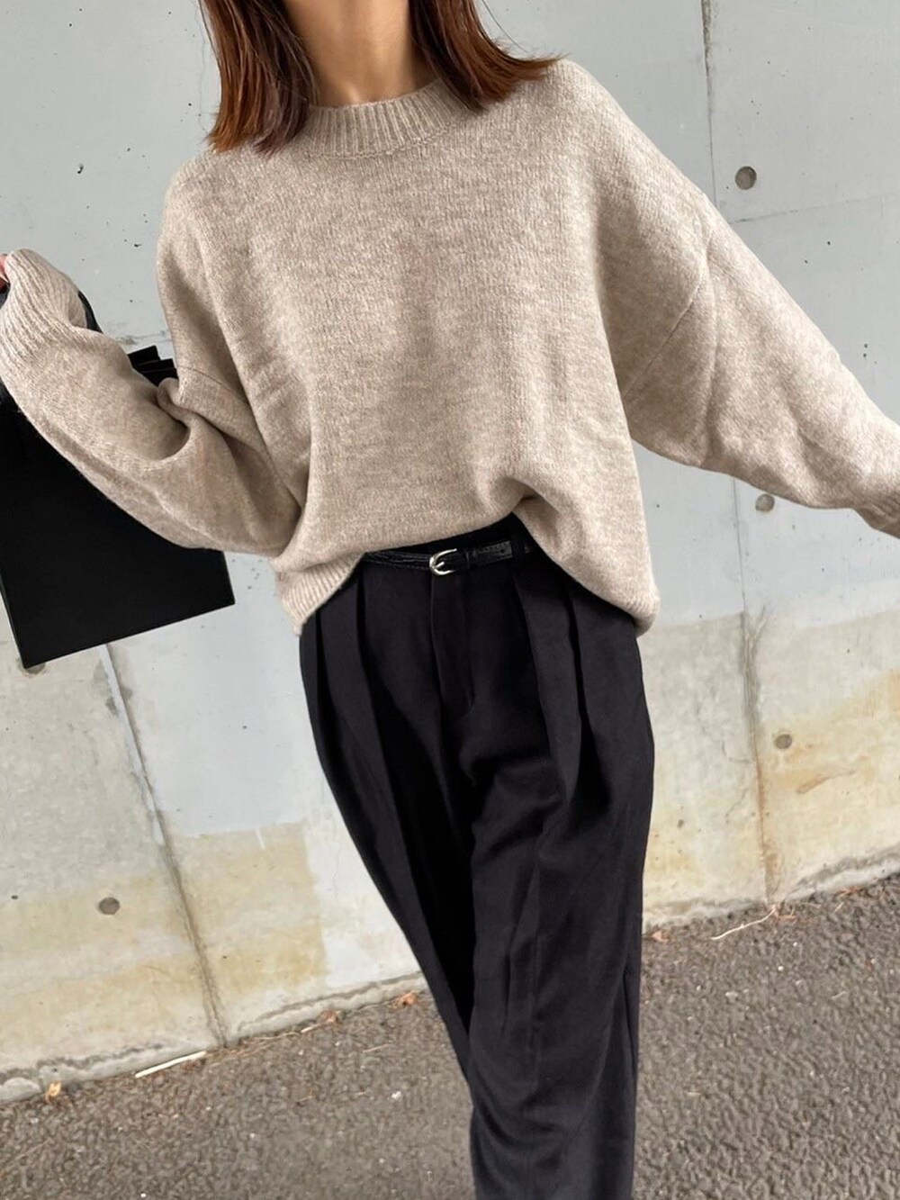ベージュ系のニット/セーター、ブラック系のパンツ、ブラック系のバッグを着用したレディースの秋コーディネートの2枚目の写真