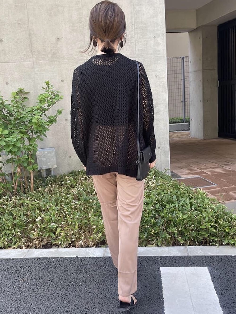 ブラック系のニット/セーター、ブラック系のタンクトップ、ベージュ系のショルダーバッグを着用したレディースの春コーディネートの4枚目の写真