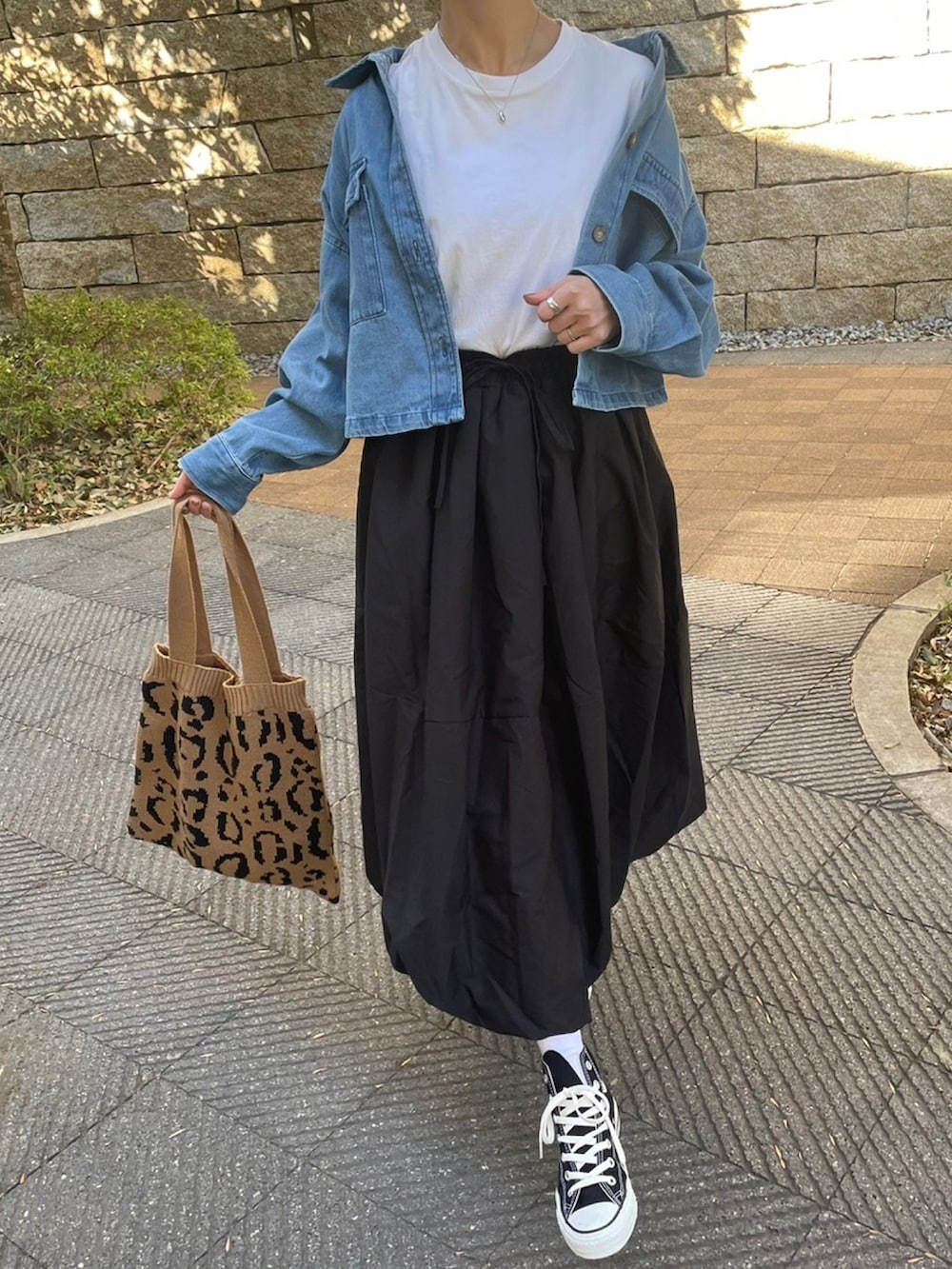 ブルー系のデニムジャケット、ブラック系のスカート、ホワイト系のTシャツ/カットソーを着用したレディースの冬コーディネートの4枚目の写真