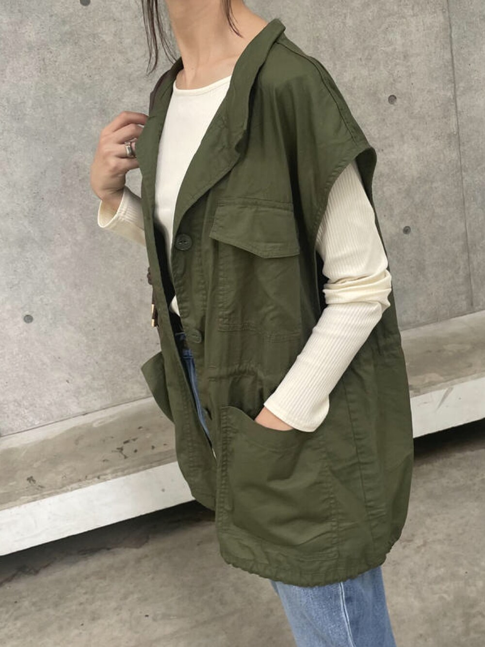 ホワイト系のTシャツ/カットソー、グリーン系のベスト、ブラウン系のショルダーバッグを着用したレディースの秋コーディネートの4枚目の写真