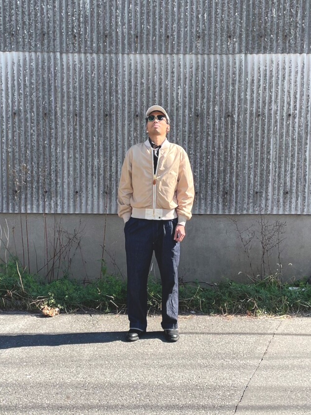 ホワイト系のMA-1、ブルー系のデニムパンツ、ブラック系のブーツを着用したメンズの冬コーディネートの2枚目の写真