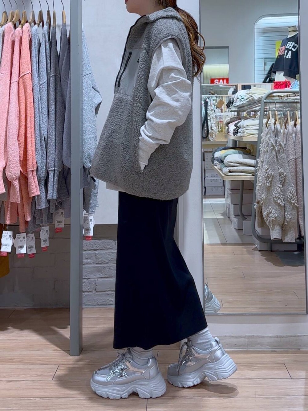 ブラック系のスカート、ブラック系のショルダーバッグ、シルバー系のスニーカーを着用したレディースの冬コーディネートの5枚目の写真