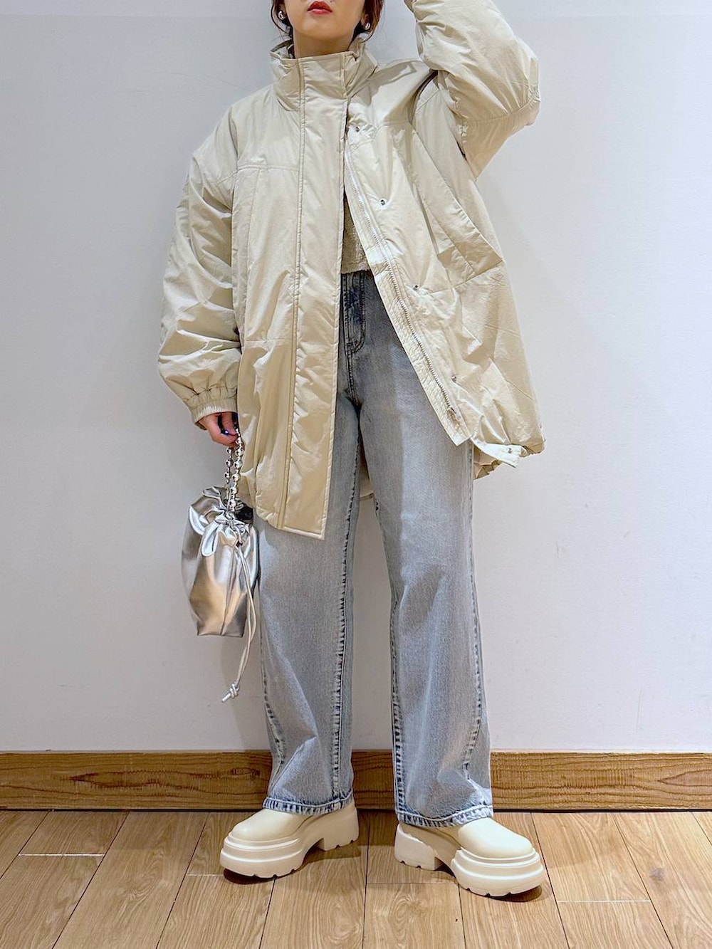 ホワイト系のダウンジャケット/コート、ブルー系のデニムパンツ、ホワイト系のブーツを着用したレディースの冬コーディネートの2枚目の写真