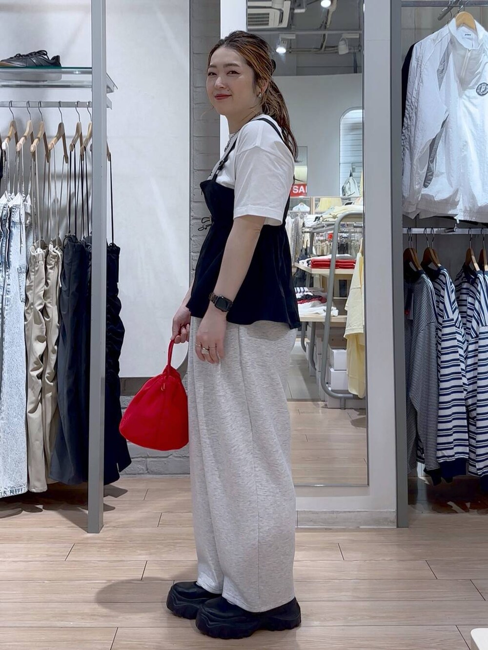 ブラック系のスニーカー、ホワイト系のTシャツ/カットソー、ブラック系のベストを着用したレディースの春コーディネートの3枚目の写真