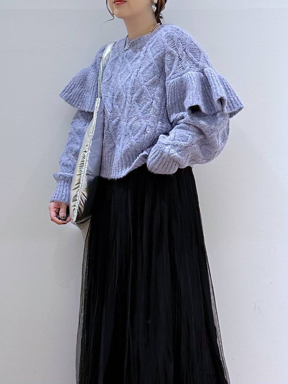 シルバー系のトートバッグ、パープル系のニット/セーター、ブラック系のブーツを着用したレディースの冬コーディネートの4枚目の写真