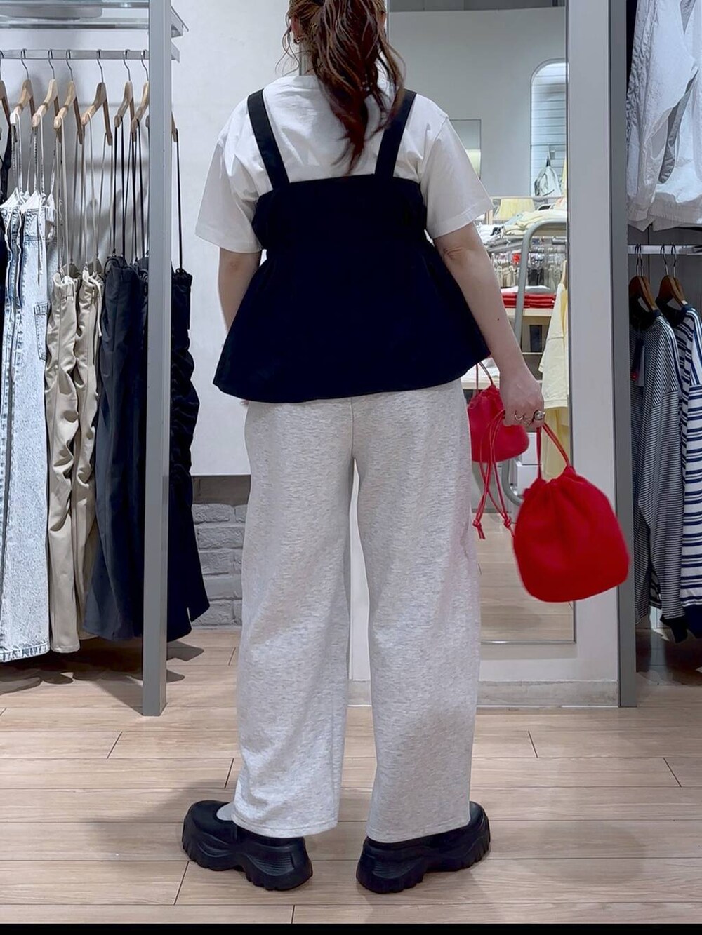 ブラック系のスニーカー、ホワイト系のTシャツ/カットソー、ブラック系のベストを着用したレディースの春コーディネートの5枚目の写真