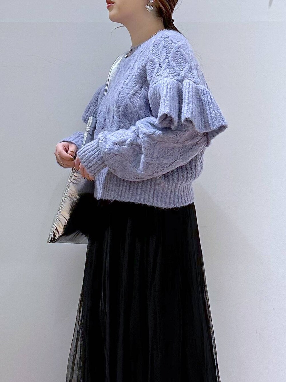 シルバー系のトートバッグ、パープル系のニット/セーター、ブラック系のブーツを着用したレディースの冬コーディネートの5枚目の写真