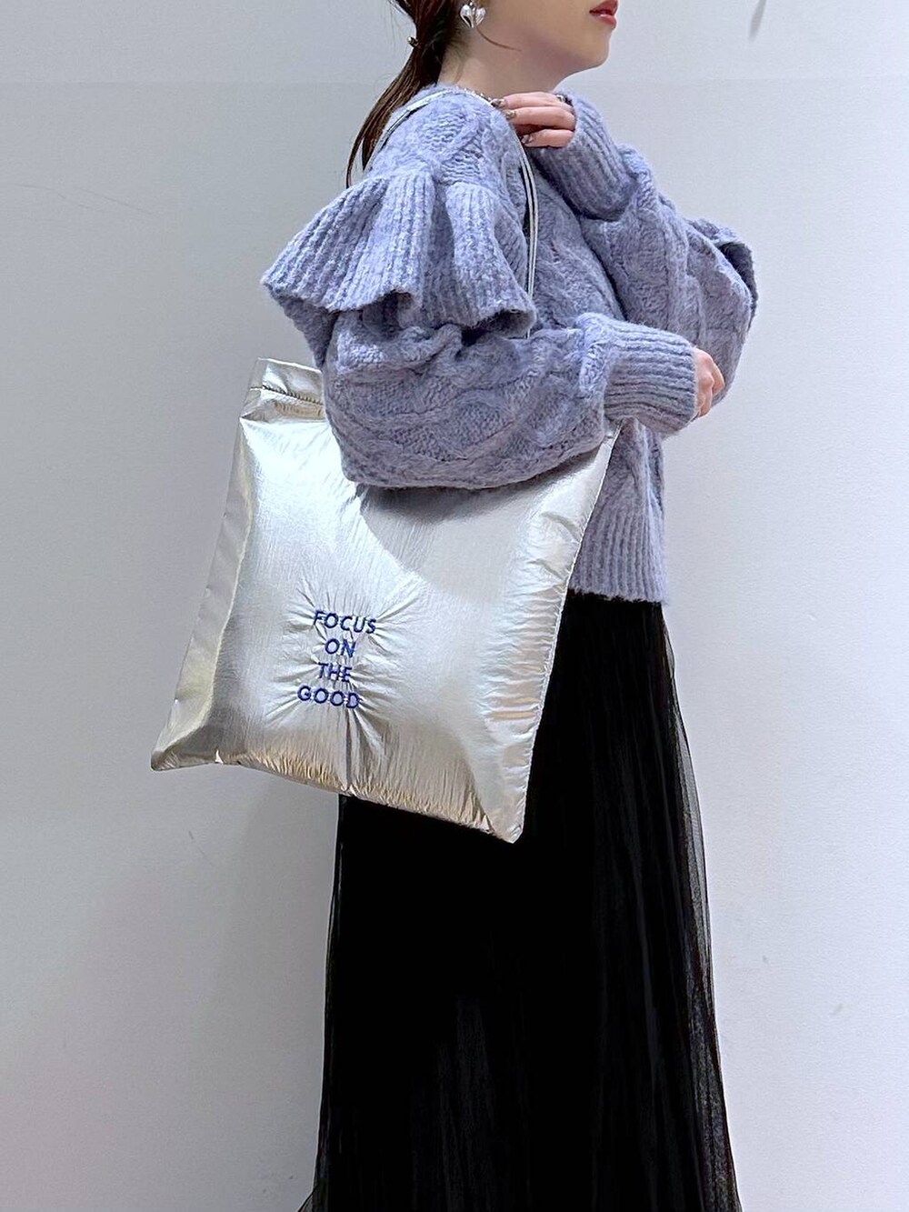 シルバー系のトートバッグ、パープル系のニット/セーター、ブラック系のブーツを着用したレディースの冬コーディネートの7枚目の写真